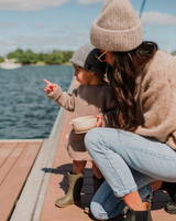 Maman et enfant sur le bord de l'eau avec bol en silicone couleur maïs.
